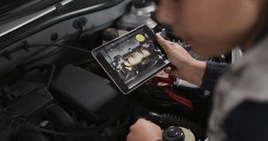 Female tech holding tablet at open car hood tapping screen, using dial, AR charts diagnosing engine. Garage, workshop, futuristic, hud, augmented, diagnostics, data - Powered by Shutterstock - Get 15% off with code: PIKWIZARD15