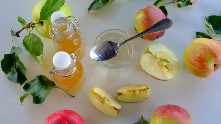 Apple cider vinegar against a background of apples. Selective focus.