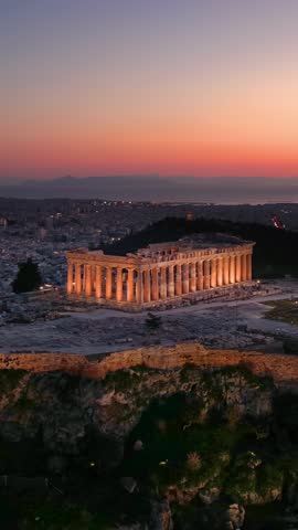 Establishing aerial view of the illuminated Parthenon Temple at the Acropolis of Athens, Greece, during dusk