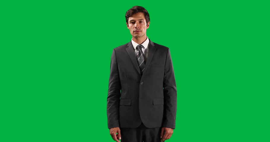 Portrait of a Caucasian businessman wearing smart clothes, with arm raised and hand out in front of him, with his index finger facing camera, touching a virtual interactive screen on green screen