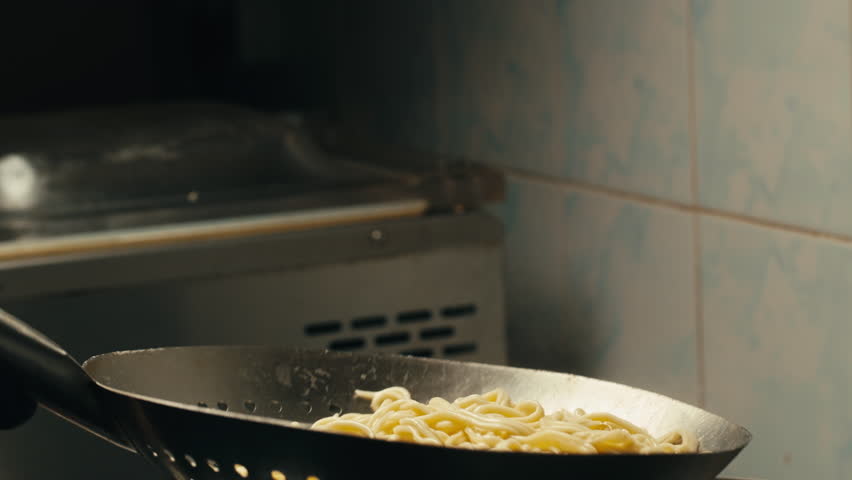 Asian Wok noodles cooking, Chef cooking handmade pasta wok frying pan close-up. Chinese traditional beef and chicken vegetables on fire pan, japanese korean pasta. Restaurant Food concept. Sea food.