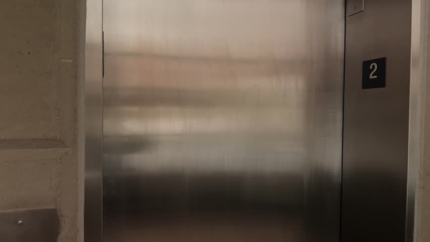Steady shot of elevator doors opening, slight pan movement, then closing again