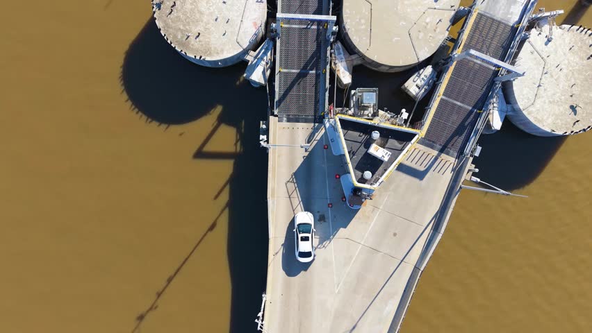 A car ferry vessel loading automobiles and commuters at the river dock in Jamestown, Virginia, captured in an aerial top-down following video.