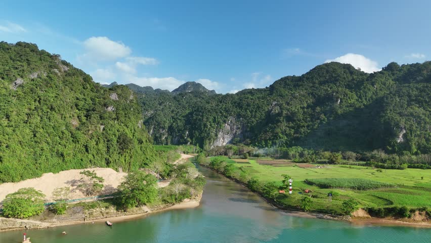 Phong Nha – Ke Bang National Park, Bo Trach, Quang Binh, Central Vietnam – 4K aerial footage of UNESCO Heritage site with Son River, limestone karst mountains, rice fields, tropical forest and cave entrance