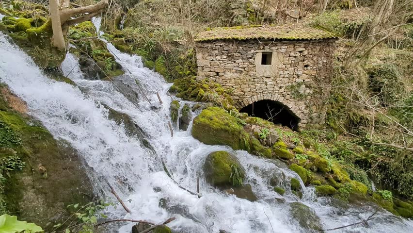 Old stone mill beside a waterfall in Belmonte de Miranda, Asturias, Spain