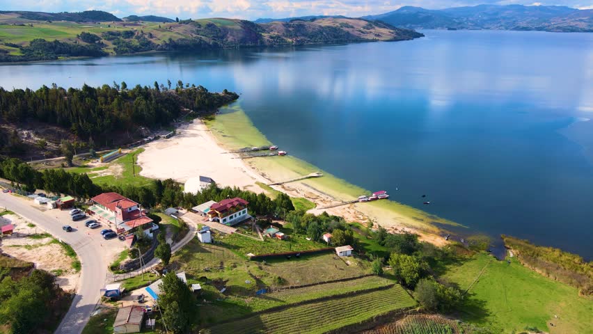 Serene aerial view of Tota Lagoon showcasing green landscapes and a peaceful shoreline under clear skies.