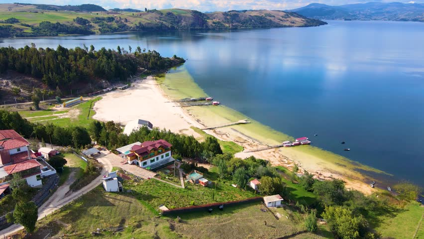 Stunning aerial snapshot of Tota Lagoon showing greenish waters and sandy beaches, with boats docked along the shore.