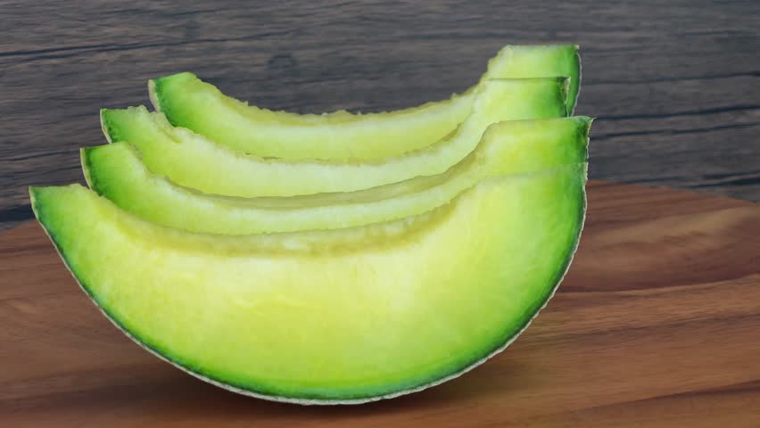 Sliced ​​cantaloupe on a wooden plate.