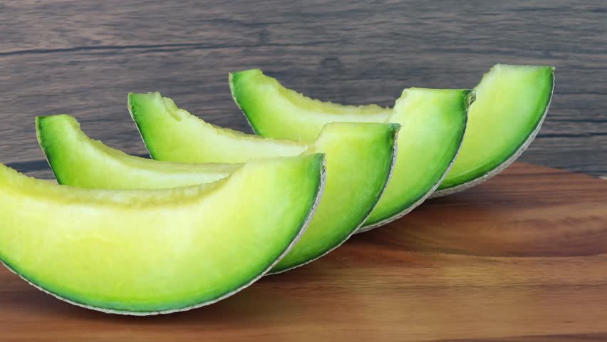 Sliced ​​cantaloupe on a wooden plate.