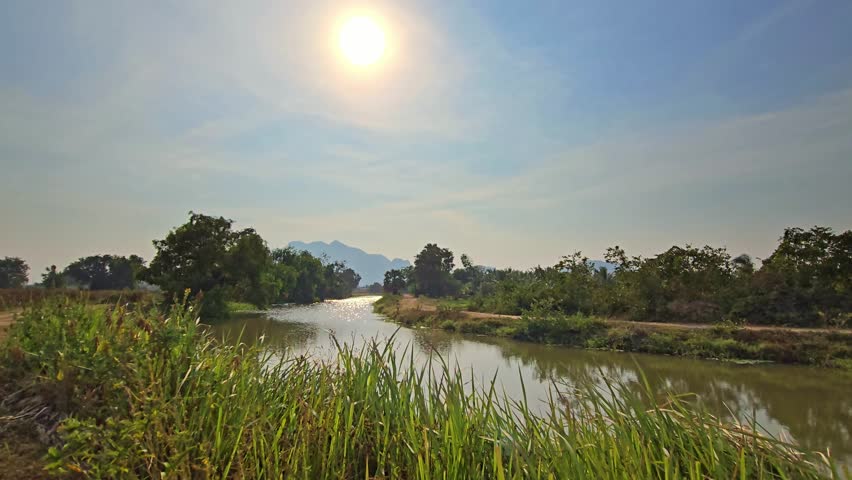 Warm Sunlight Glowing Over River in Scenic Thailand Landscape