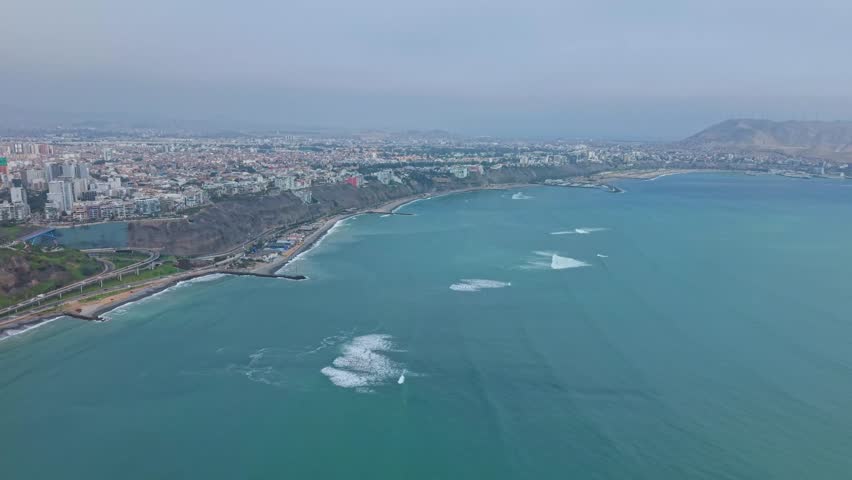 Aerial view of Lima coast revealing cityscape and ocean in Peru