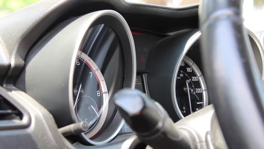 A closeup of a tachometer of a car moving as the engine is revving