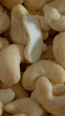 Vertical Screen: Cashew pieces fill a rustic bowl, showcasing their smooth texture and nutty flavor. These versatile snacks are ideal for cooking, baking, or enjoying on their own.