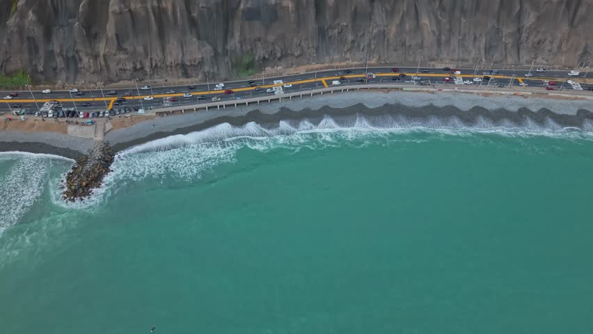 Aerial tilt reveal of coastal road in Lima, Peru, with ocean view