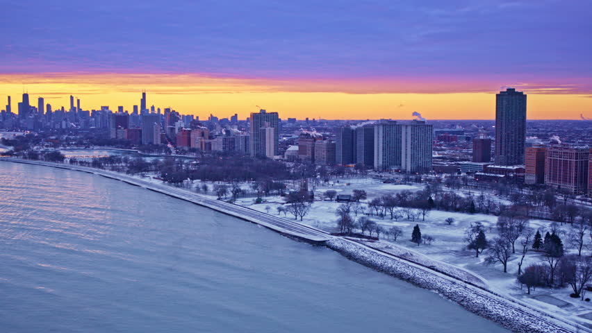 dramatic drone shot panning across a urban landscape with the skyline and lake michigan