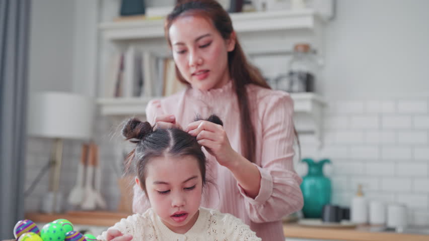Caring Asian mother styles her daughter
