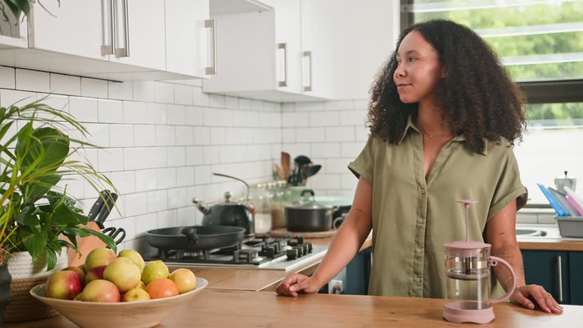 Woman Smiling While Getting A Coffee Mug From A Kitchen Cabinet For Her Morning Routine