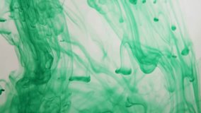 Swirling clouds of vibrant green ink diffusing and flowing through clear water against a bright white studio background for art - Powered by Shutterstock - Get 15% off with code: PIKWIZARD15