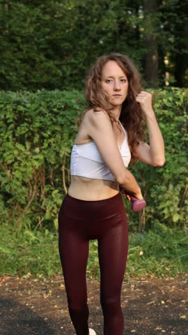 Determined Woman In Athletic Attire Practicing Warmup And Musclebuilding Movements In Park