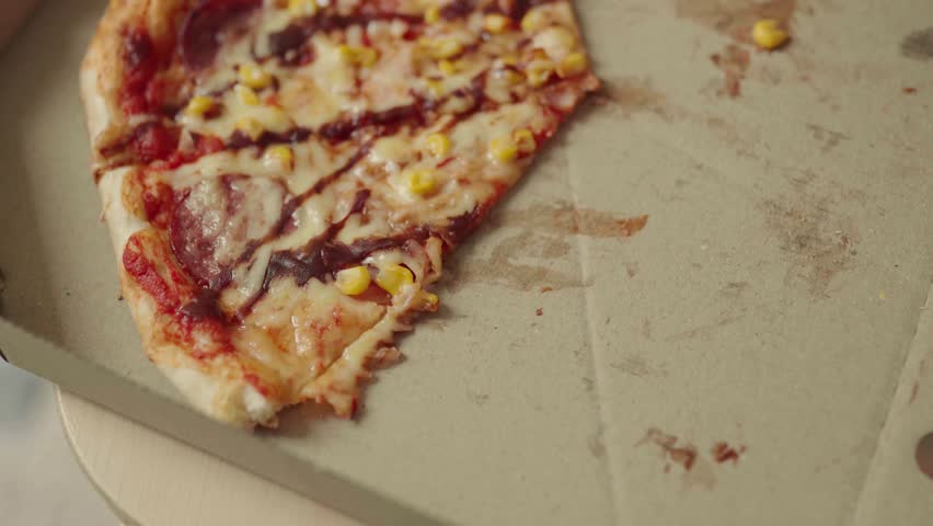 Close up of male hands taking a hot pepperoni pizza slice from a delivery box.