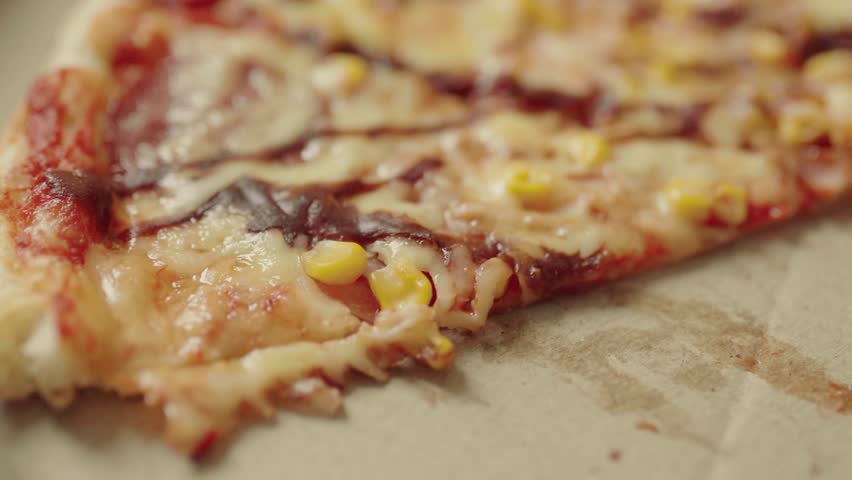 Close up of male hands taking a hot pepperoni pizza slice from a delivery box.