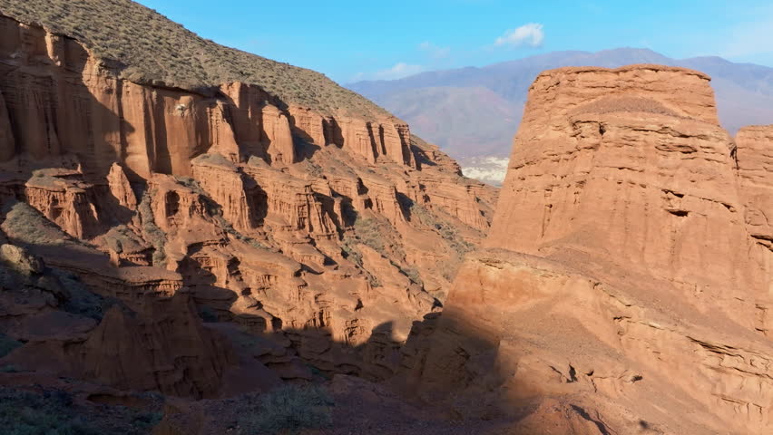 Drone view of eroded sandstone cliff in Konorchek canyons in Kyrgyzstan at dusk.