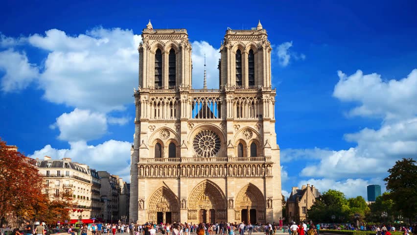 Front View of Notre Dame de Paris Cathedral Facade with Tourists and Blue Sky