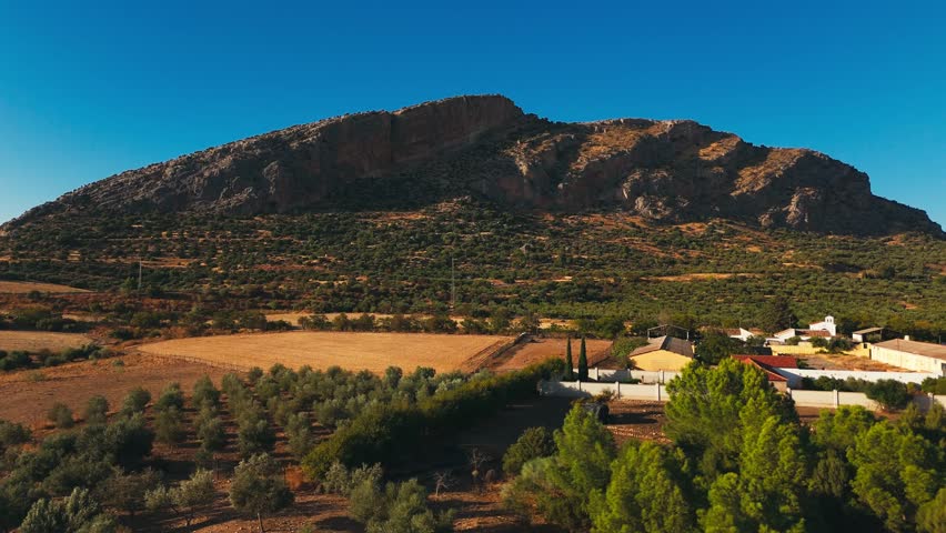 Rural valley with small village beneath rocky mountain