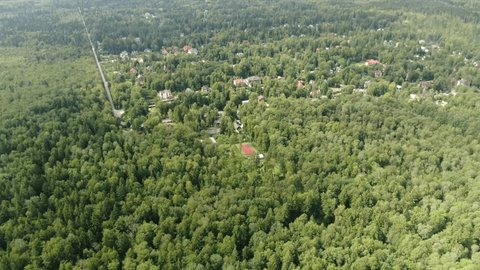 Drone Flying Backward above Forest Settlement