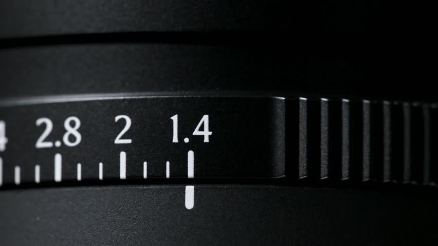 Macro shot of a lens aperture ring moving thru the f:1.4 marking and tick marks all the way to f:16 and Auto.