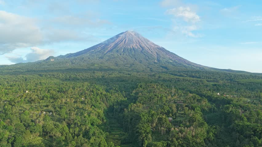 Majestic aerial view of the active semeru volcano, the highest mountain on the island of java, surrounded by lush tropical forest