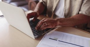 Hands, laptop and paper with man in coffee shop for budget, financial report or remote work. Computer, documents and finance with freelance employee typing in cafe or restaurant for revenue update - Powered by Shutterstock - Get 15% off with code: PIKWIZARD15