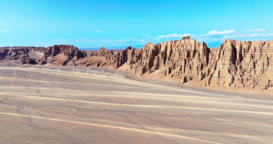 Aerial view of rugged jagged rock formations and a vast desert expanse in the remote wilderness of Xinjiang, China.