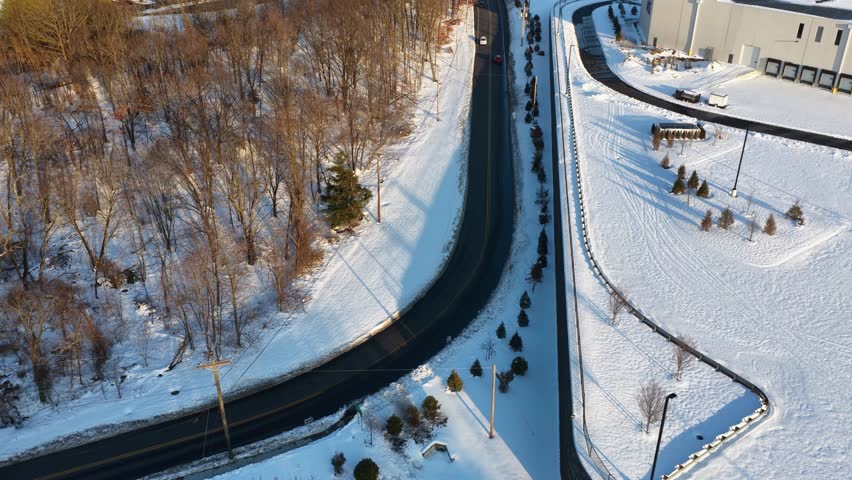 Aerial Flight Along Snow Covered Road in Winter Landscape