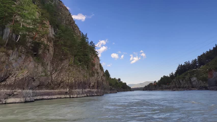 A motorboat ride along mountain river. Slow motion of speedboating on Altai river Katun in rainy day.