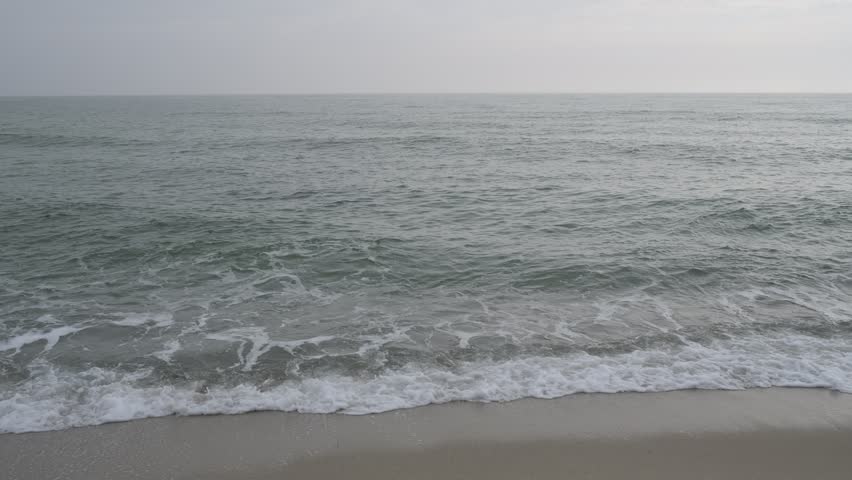 Calm sea waves with natural sound, peaceful ocean shoreline on a cloudy day, off-season beach background