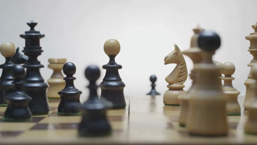 Close-up of a chess game with a white knight capturing a black bishop and a black pawn capturing a white knight, shown on a rotating board.