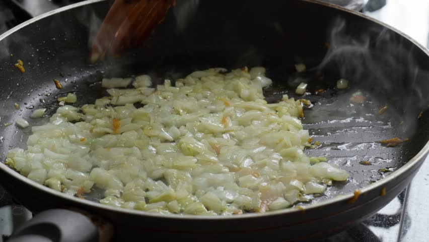 Sauteing Chopped Onions and Grated Carrots in a Pan