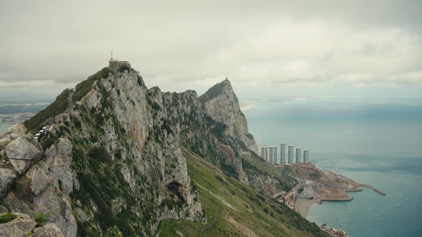 Wide panoramic view of the Rock of Gibraltar ridge with dramatic cliffs overlooking the Mediterranean coastline and city below.