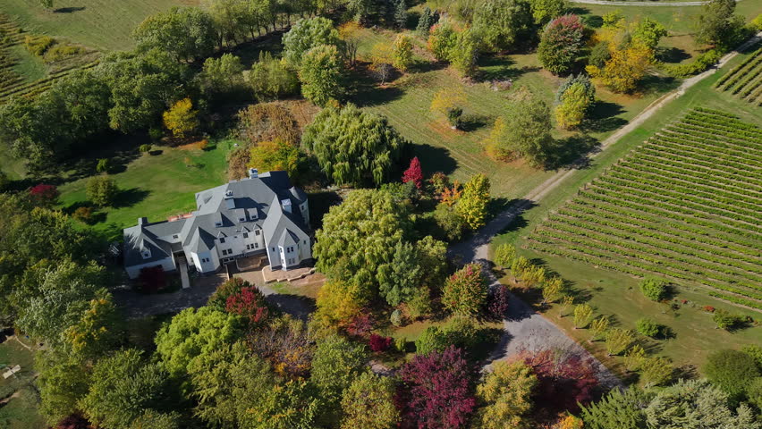 Beautiful countryside mansion with vineyard and autumn trees in New York State USA aerial view.