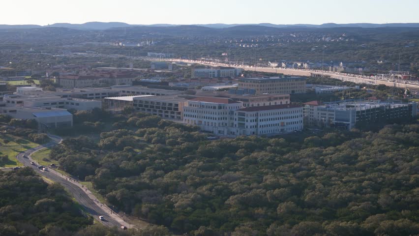 A aerial drone shot of The University of Texas at San Antonio just off the major interstate highway I-10 near The Rim on the Northwest side of the city. The sun is beginning to set.