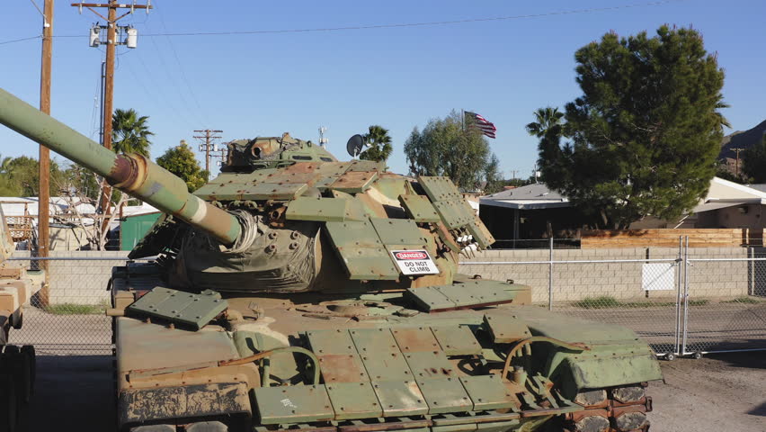 Clear side profile of a historic olive green military battle tank displayed outdoors at the General Patton Museum in the Mojave desert