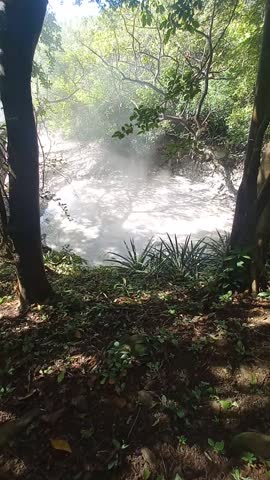 Close up of bubbling mud pots and sulfuric steam rising from fumaroles on the 3.5 km loop trail, Las Pailas sector, Costa Rica volcanic landscape.