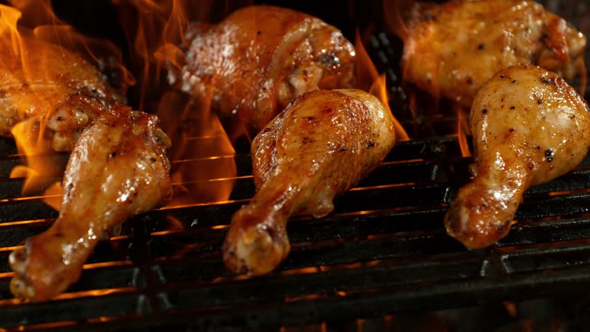 Super Slow Motion of Delicious Chicken Legs on a Grill with Roaring Flames