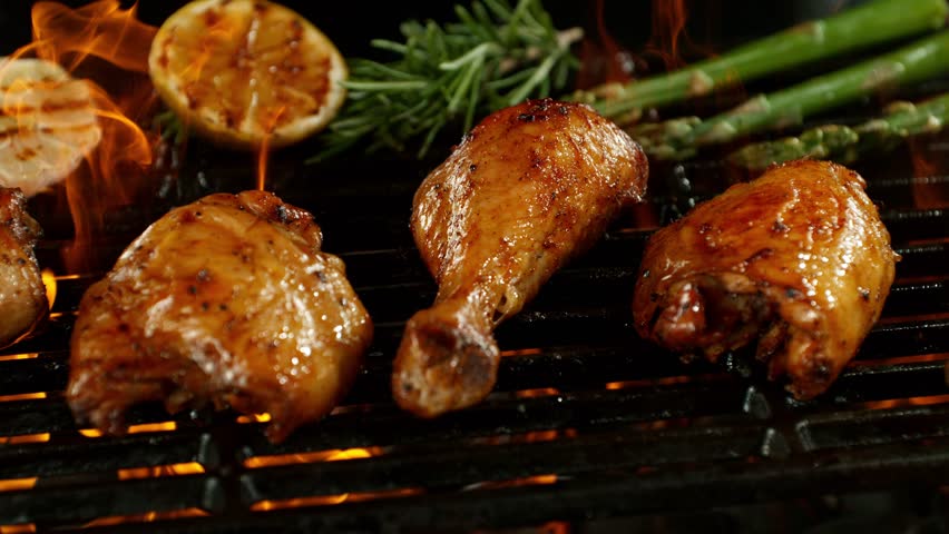 Super Slow Motion of Delicious Chicken Legs on a Grill with Roaring Flames