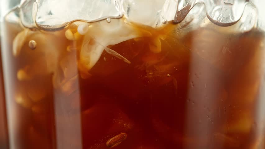 Super Slow Motion Shot of Pouring Milk into Ice Coffee , Filmed on High Speed Cinematic Camera