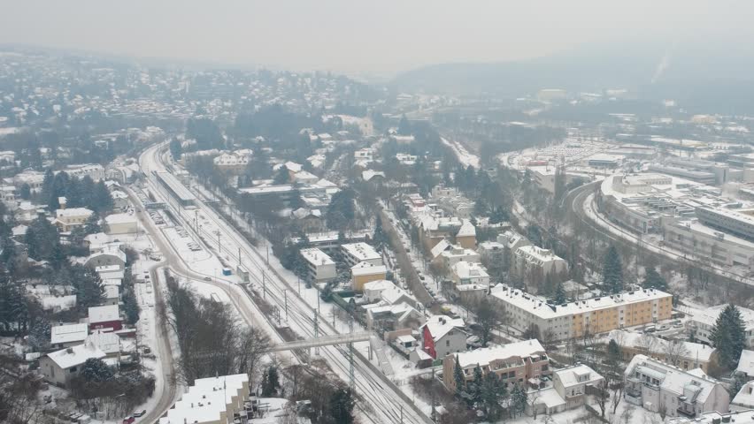 Aerial view of residential district of Vienna in winter with station and railway tracks