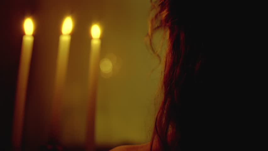 silhouette fantasy woman queen vampire walking in dark room holding old candlestick in hands candles burning warm light. Vintage victorian old style white dress. Sexy girl back rear view. black night
