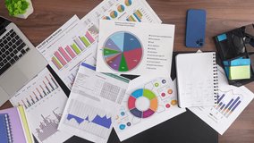 Image showing a business handshake over various financial documents, charts, and graphs on a desk, symbolizing collaboration and financial analysis. Top shot, slow motion - Powered by Shutterstock - Get 15% off with code: PIKWIZARD15