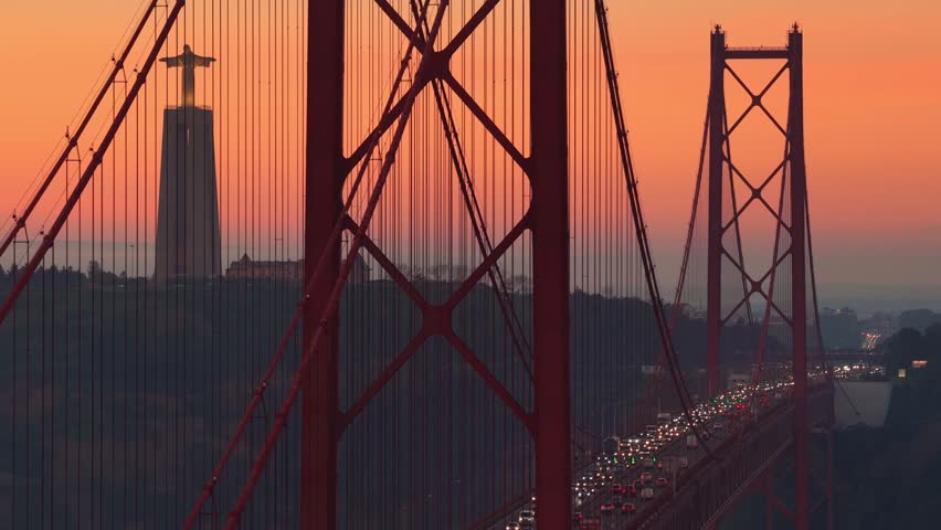 Aerial view of Lisbon, capital of Portugal. Sunrise at the bridge the 25 of April in the centre of Lisbon, Famous Cristo Rei statue with the bridge 25 de Abril drone view